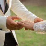 man in black suit jacket holding womans hand