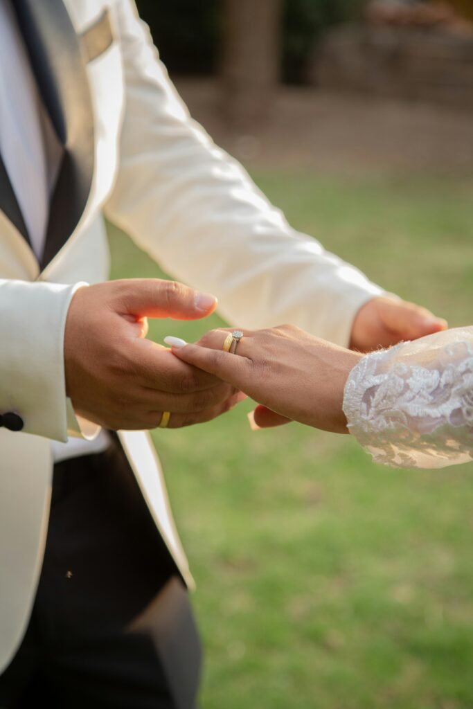 man in black suit jacket holding womans hand